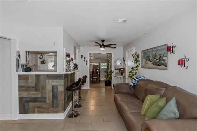 tiled living room with ceiling fan