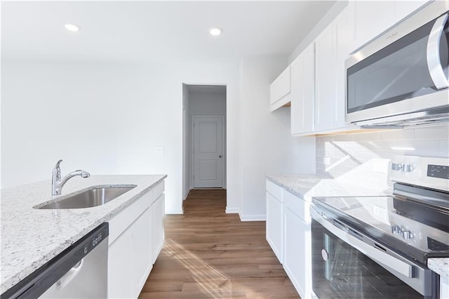 650 Cayenne Way, Lawrenceville, GA 30045 - kitchen with stainless steel appliances, a sink, white cabinetry, light stone counters, and wood finished floors