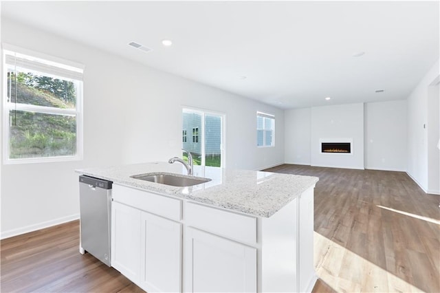 650 Cayenne Way, Lawrenceville, GA 30045 - kitchen featuring stainless steel dishwasher, a sink, light stone counters, a kitchen island with sink, and healthy amount of natural light