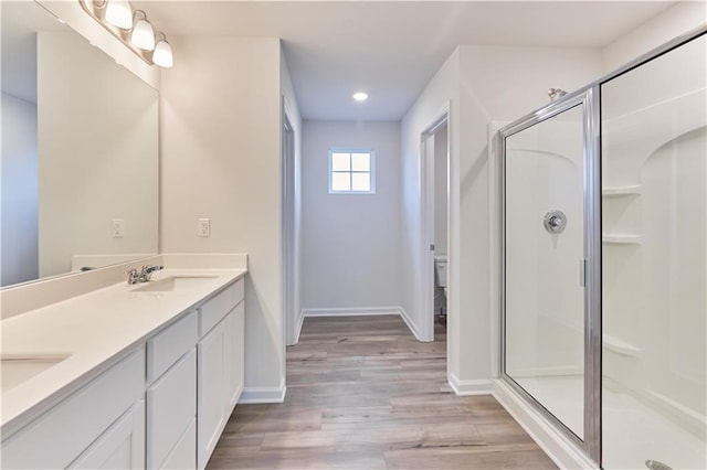 650 Cayenne Way, Lawrenceville, GA 30045 - bathroom featuring double vanity, a shower stall, baseboards, wood finished floors, and recessed lighting
