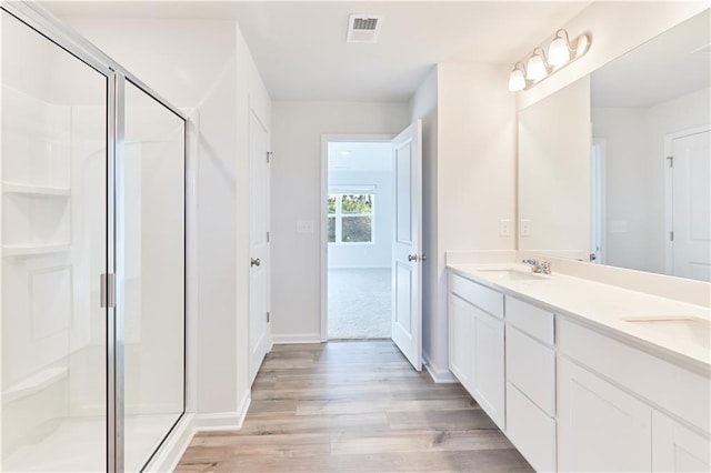 650 Cayenne Way, Lawrenceville, GA 30045 - bathroom featuring wood finished floors, double vanity, a shower stall, and baseboards