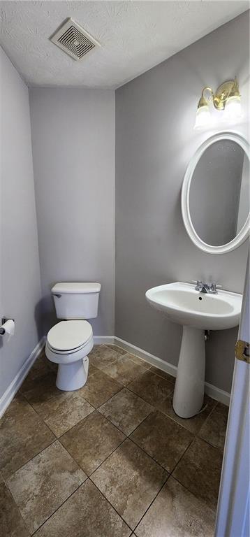1230 Chris Lake Dr, Lawrenceville, GA 30046 - bathroom featuring toilet, baseboards, and a textured ceiling