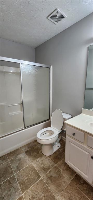 1230 Chris Lake Dr, Lawrenceville, GA 30046 - bathroom featuring toilet, vanity, combined bath / shower with glass door, a textured ceiling, and tile patterned floors