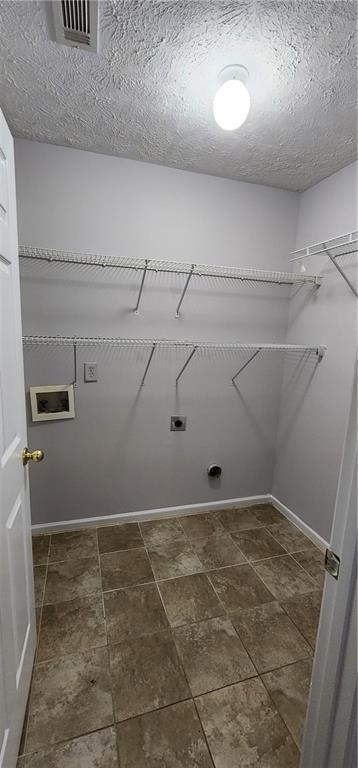 1230 Chris Lake Dr, Lawrenceville, GA 30046 - washroom with electric dryer hookup, dark stone finish floors, and a textured ceiling