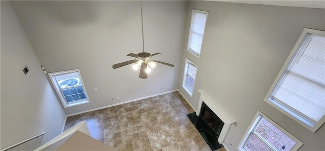 1230 Chris Lake Dr, Lawrenceville, GA 30046 - unfurnished living room with a towering ceiling, ceiling fan, a fireplace with flush hearth, and baseboards