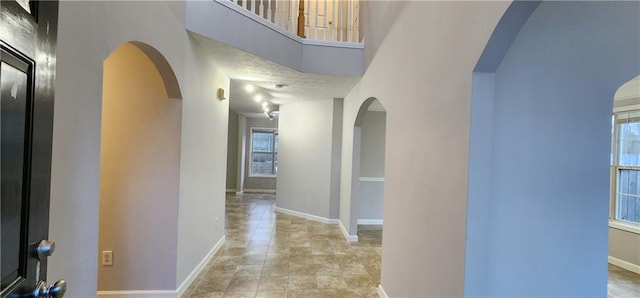 1230 Chris Lake Dr, Lawrenceville, GA 30046 - hall featuring arched walkways, plenty of natural light, baseboards, and a towering ceiling
