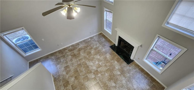 1230 Chris Lake Dr, Lawrenceville, GA 30046 - unfurnished living room with a towering ceiling, ceiling fan, a fireplace with raised hearth, and baseboards