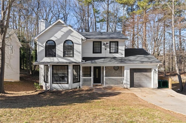 view of front of property featuring a garage, a front yard, and covered porch