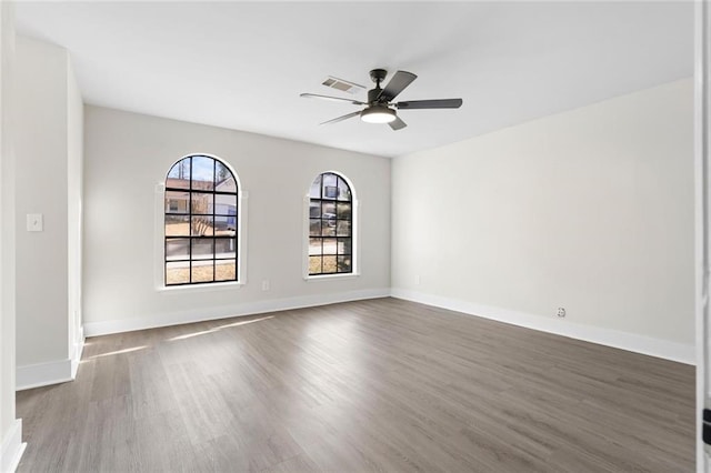 spare room featuring dark wood-type flooring and ceiling fan