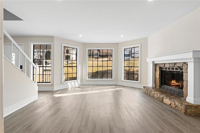 unfurnished living room featuring hardwood / wood-style flooring, plenty of natural light, and a fireplace