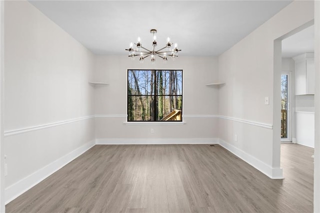 unfurnished dining area featuring wood-type flooring and an inviting chandelier