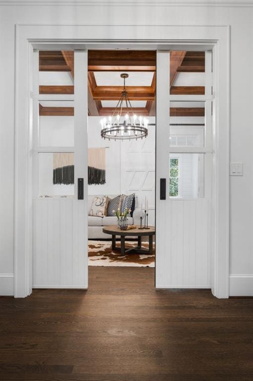 entryway with beam ceiling, an inviting chandelier, and dark hardwood / wood-style flooring