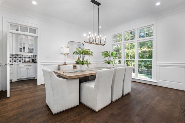 dining area with crown molding, dark hardwood / wood-style floors, and a chandelier