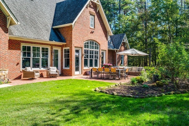 rear view of house featuring a patio, an outdoor living space, and a lawn