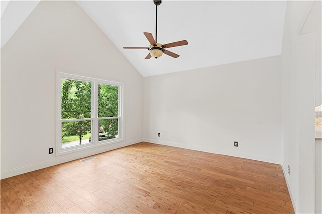 spare room featuring ceiling fan, light wood finished floors, high vaulted ceiling, and baseboards