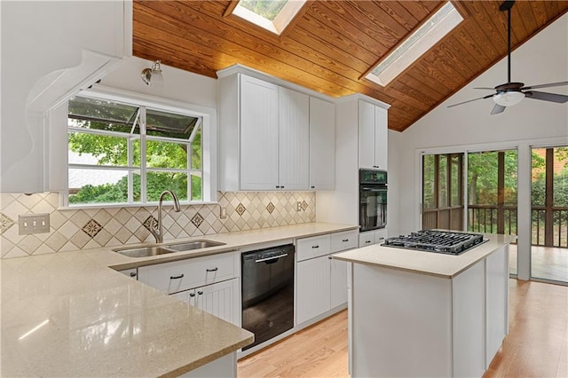 kitchen featuring a sink, wood ceiling, black appliances, a skylight, and vaulted ceiling