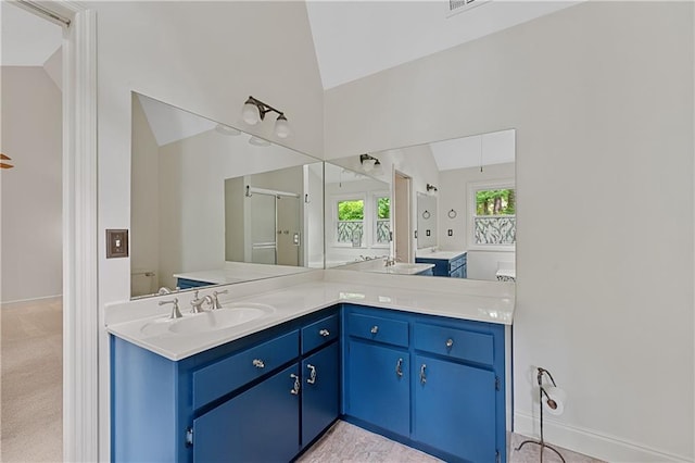 bathroom featuring vaulted ceiling, vanity, a shower stall, and baseboards