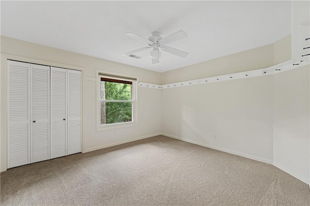 unfurnished bedroom featuring carpet, baseboards, a closet, and ceiling fan
