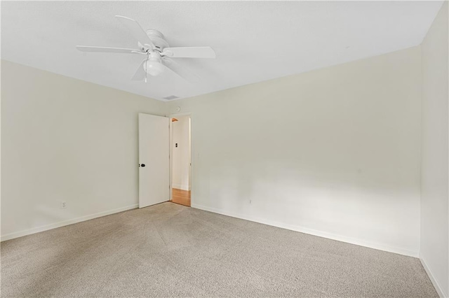 carpeted empty room featuring baseboards and ceiling fan