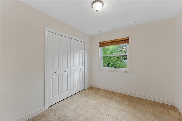 unfurnished bedroom featuring baseboards and a closet