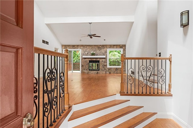staircase featuring hardwood / wood-style floors, ceiling fan, and baseboards