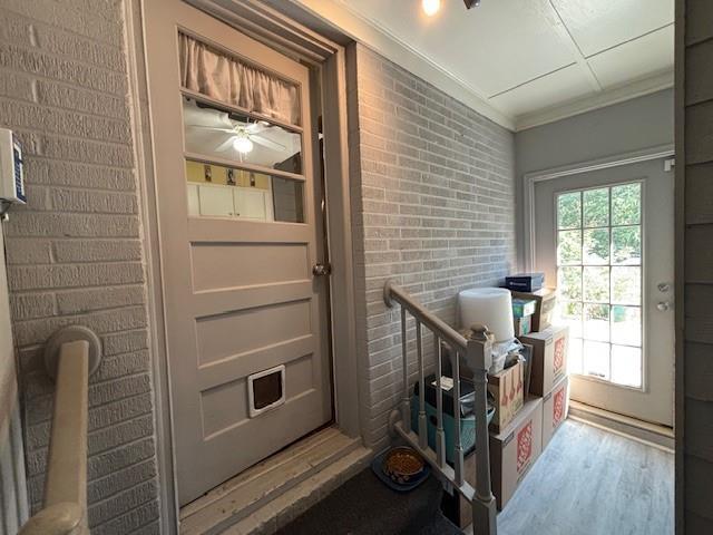 4519 Sims Ct, Tucker, GA 30084 - doorway to outside with a ceiling fan, brick wall, ornamental molding, and wood finished floors