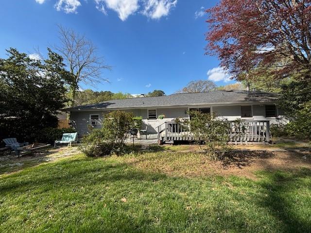 4519 Sims Ct, Tucker, GA 30084 - rear view of house featuring a lawn, an outdoor fire pit, and a deck