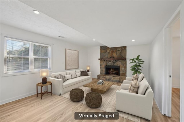 living area with visible vents, a fireplace, light wood-type flooring, baseboards, and recessed lighting