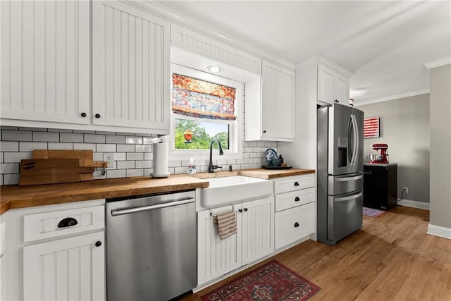 322 Windy Ridge Dr, Demorest, GA 30535 - kitchen with appliances with stainless steel finishes, wood counters, backsplash, crown molding, and light wood-style flooring