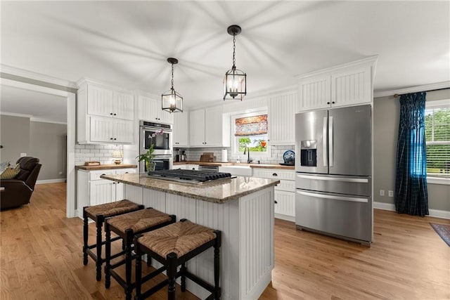 322 Windy Ridge Dr, Demorest, GA 30535 - kitchen featuring stainless steel appliances, light wood-type flooring, tasteful backsplash, white cabinets, and crown molding