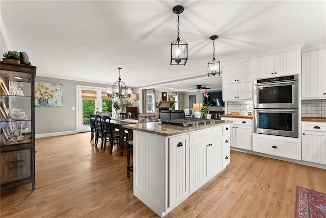 322 Windy Ridge Dr, Demorest, GA 30535 - kitchen with stainless steel appliances, a kitchen island, decorative backsplash, and white cabinets