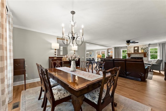 322 Windy Ridge Dr, Demorest, GA 30535 - dining room featuring a chandelier, ceiling fan, a large fireplace, wood finished floors, and ornamental molding
