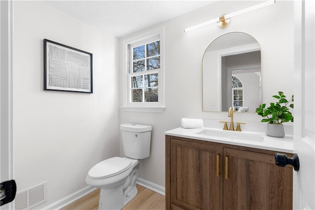 bathroom with hardwood / wood-style flooring, vanity, and toilet