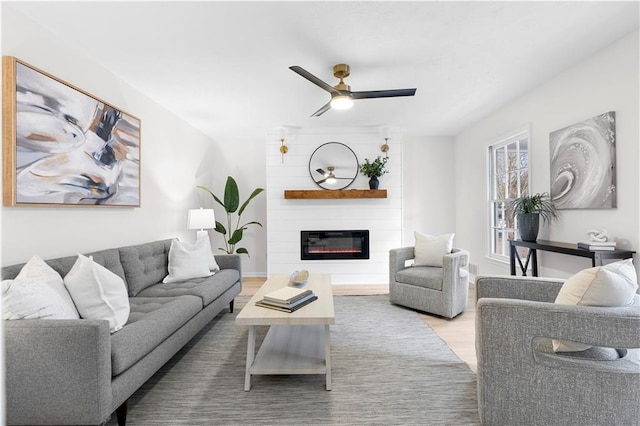 living room featuring hardwood / wood-style flooring, a fireplace, and ceiling fan