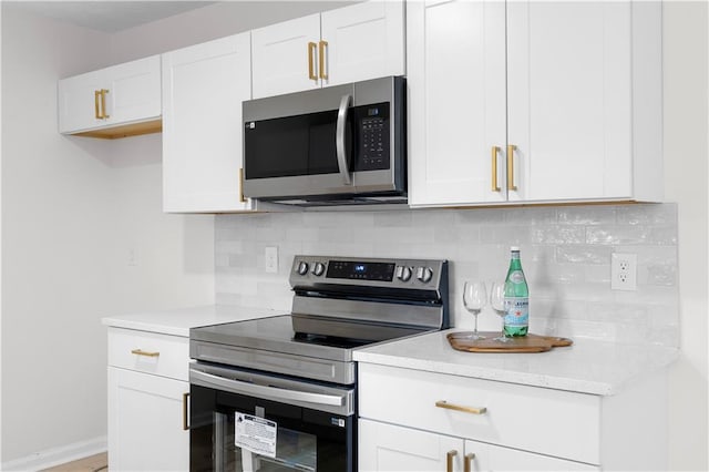 kitchen featuring white cabinetry, stainless steel appliances, and decorative backsplash