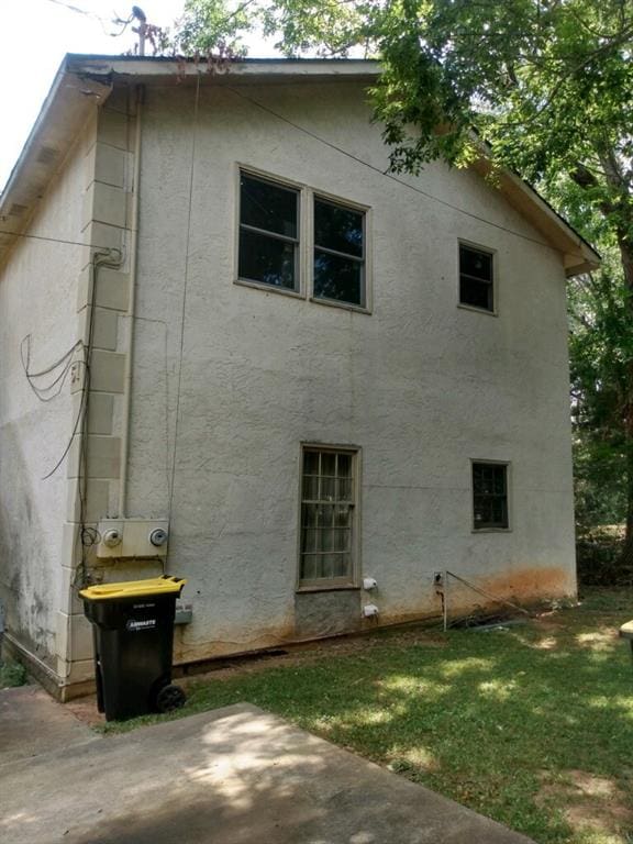 51 Mullis St, Fairburn, GA 30213 - view of side of property with stucco siding, a patio area, and a yard