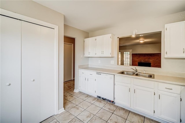 kitchen with white dishwasher, sink, white cabinetry, and light tile patterned floors