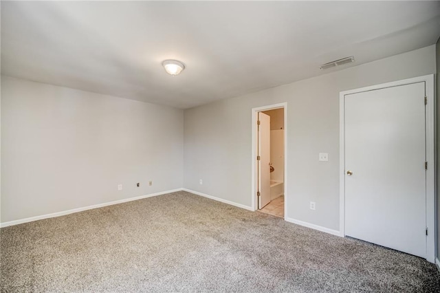 unfurnished bedroom with light colored carpet and ensuite bathroom