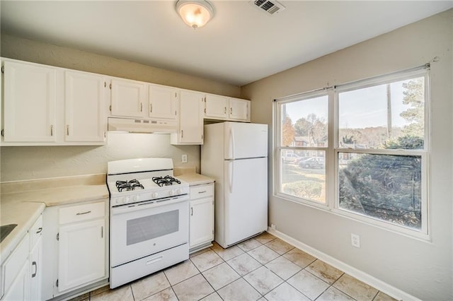 kitchen featuring light tile patterned floors, white appliances, and white cabinets