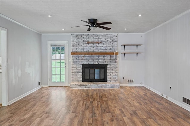 120 Lakeside Dr, Ellenwood, GA 30294 - unfurnished living room with wood finished floors, crown molding, ceiling fan, a brick fireplace, and a textured ceiling
