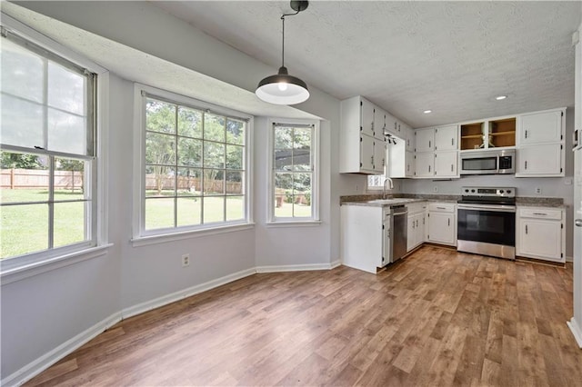120 Lakeside Dr, Ellenwood, GA 30294 - kitchen featuring stainless steel appliances, wood finished floors, white cabinetry, a textured ceiling, and recessed lighting
