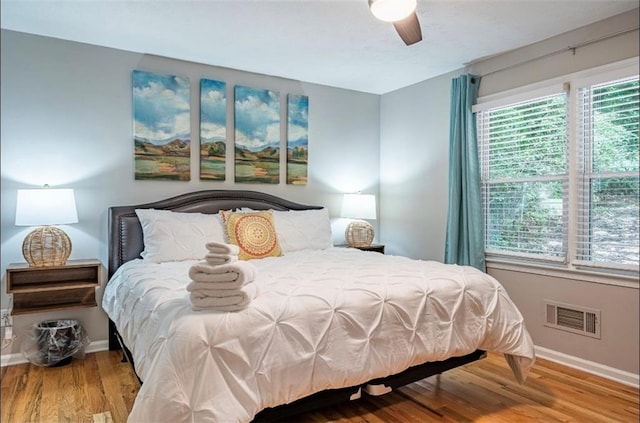 bedroom featuring baseboards, wood finished floors, and ceiling fan