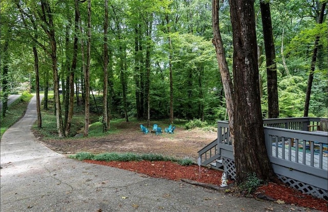 view of yard with a wooden deck and a forest view