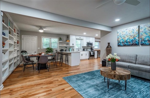 living room with ceiling fan, light wood finished floors, and recessed lighting