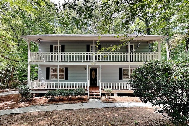 view of front property with a porch and a balcony