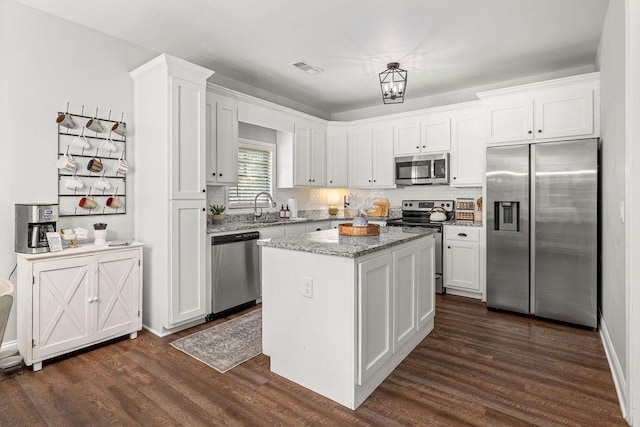 kitchen featuring white cabinetry, stainless steel appliances, and dark wood-type flooring