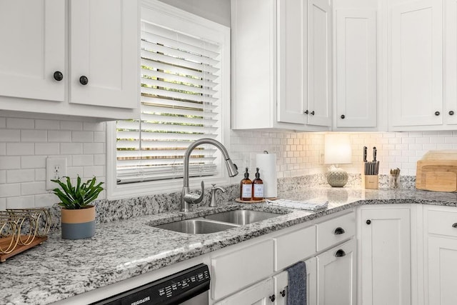 kitchen with a sink, white cabinetry, light stone countertops, dishwasher, and tasteful backsplash