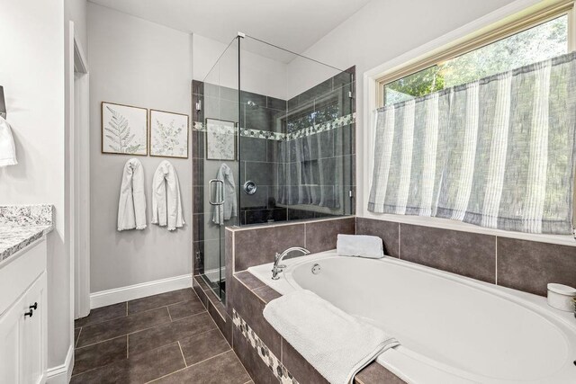 bathroom with vanity, a shower stall, a bath, baseboards, and tile patterned floors