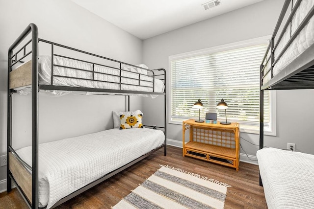 bedroom featuring wood finished floors, visible vents, and baseboards