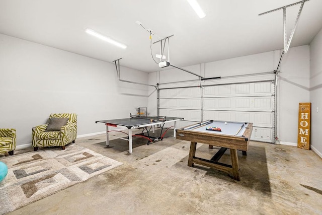 game room with a garage, unfinished concrete flooring, and baseboards